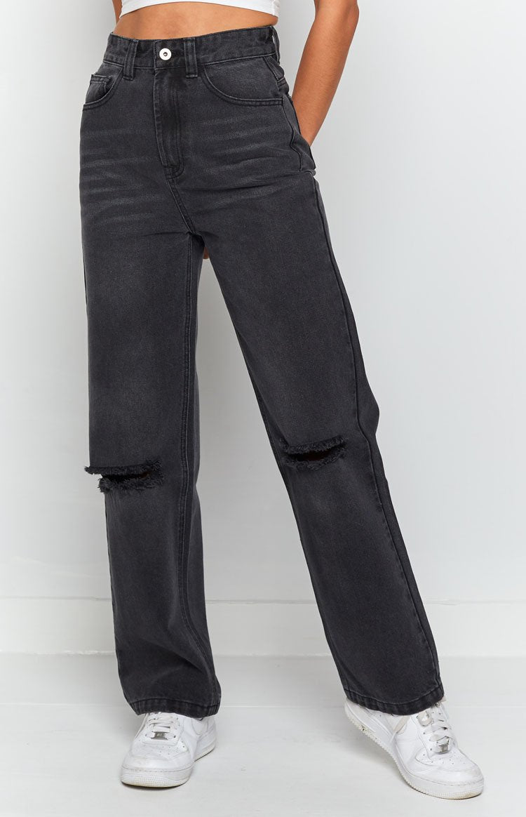 High waisted black wash wide leg jeans with distressed ripped knees and a faded denim texture