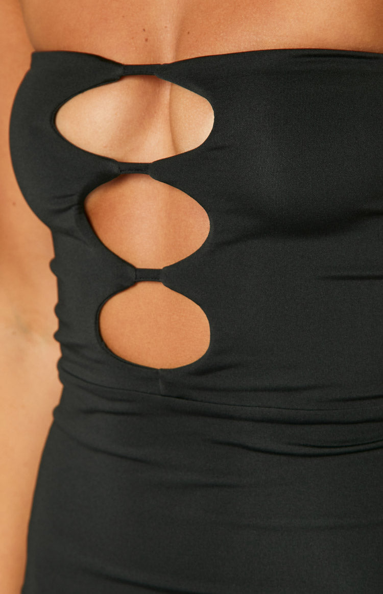 Close-up of the three oval cutouts connected by thin fabric strips on the black dress
