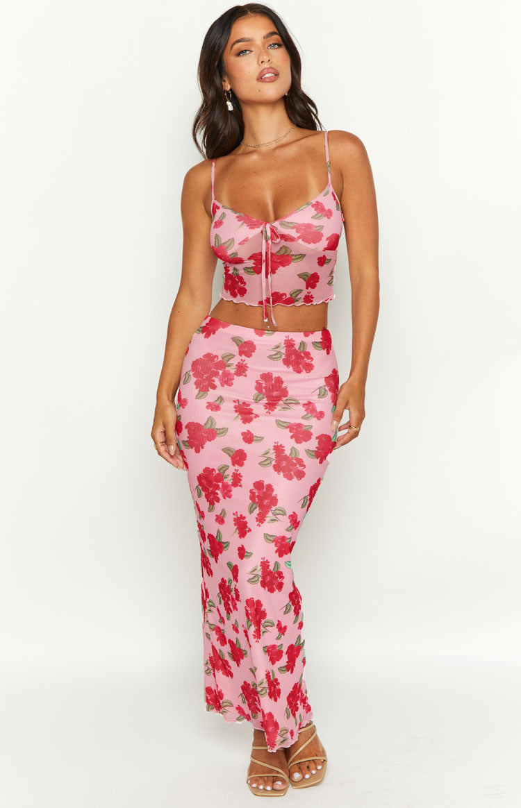 Pink mesh cami with red floral print, thin spaghetti straps, tie-front detail, and ruffled cropped hem