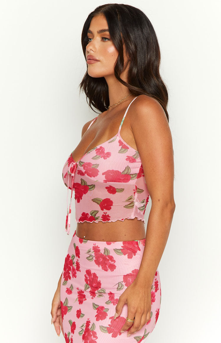Side view of a pink mesh cami with red floral print, tie-front detail, and scalloped hem
