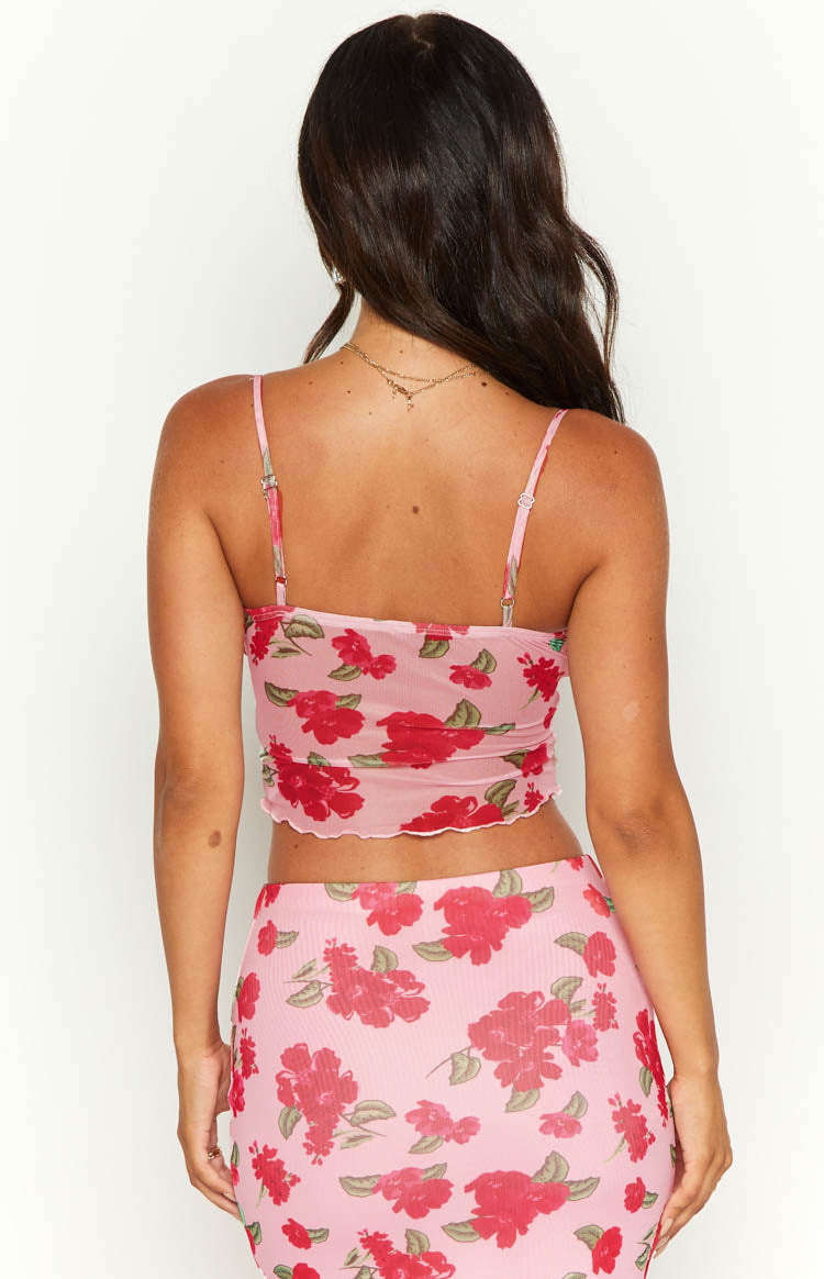 Rear view of a pink mesh cami with red floral print, thin adjustable spaghetti straps, and lettuce-edge hem