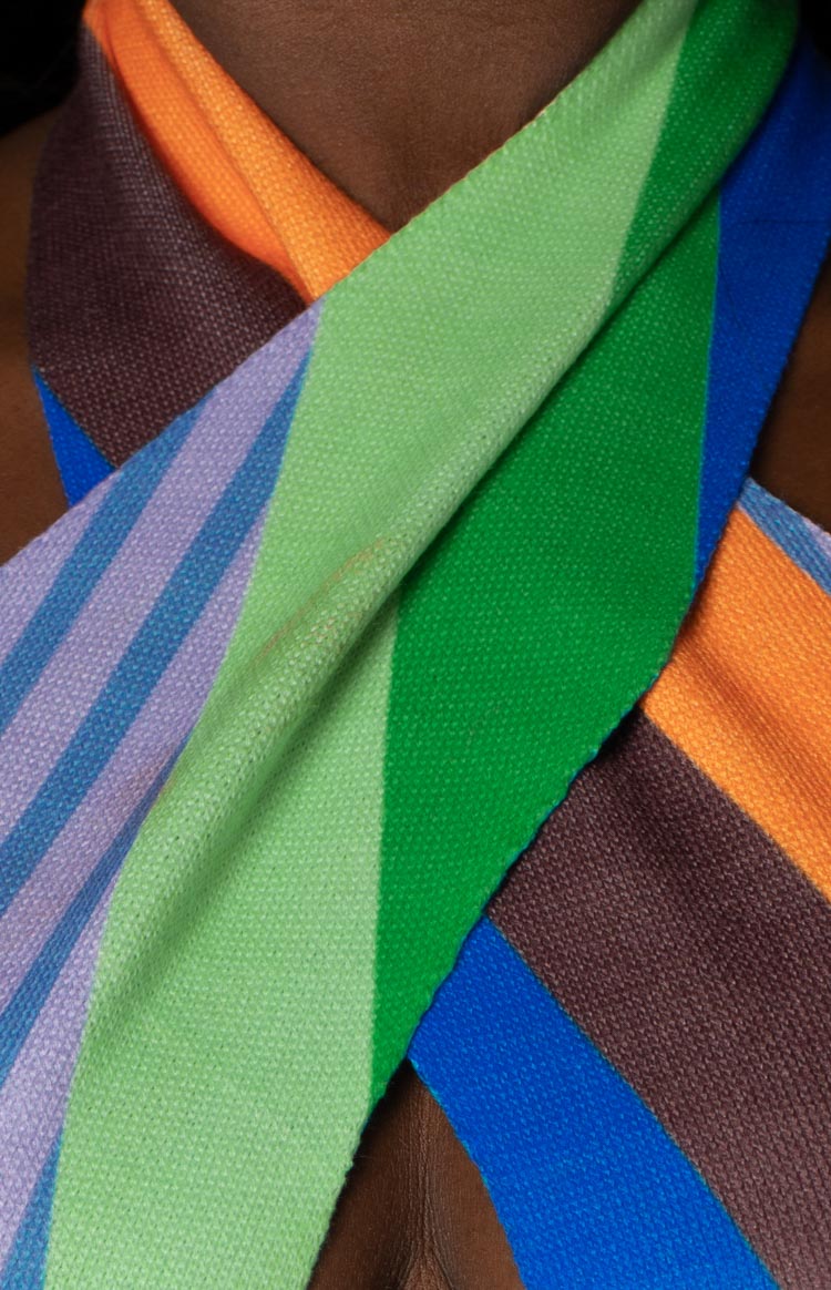 Close-up of the multi-coloured knit halter neckline showing the criss-cross design and striped pattern