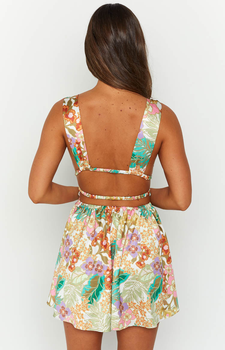 Rear view of the white tropical floral mini dress featuring a wide strap open back and elasticated waist cutouts