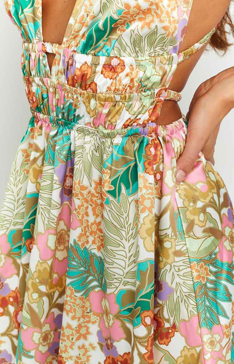 Close-up of the shirred waist and side cutouts on a tropical floral mini dress