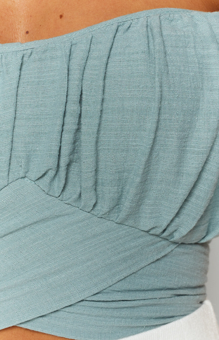 Sage crinkled grid fabric wrap top featuring a gathered bodice and wide criss-cross waistband