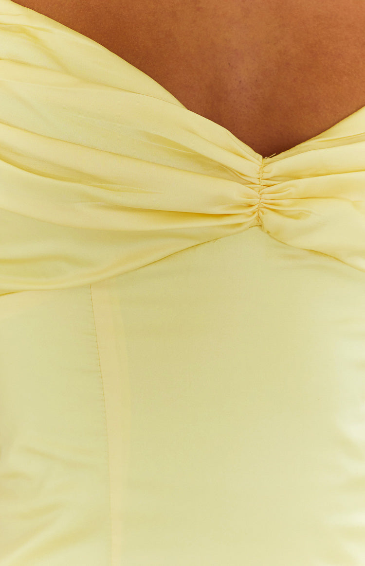 Close-up of the ruched sweetheart neckline of a honey yellow maxi dress
