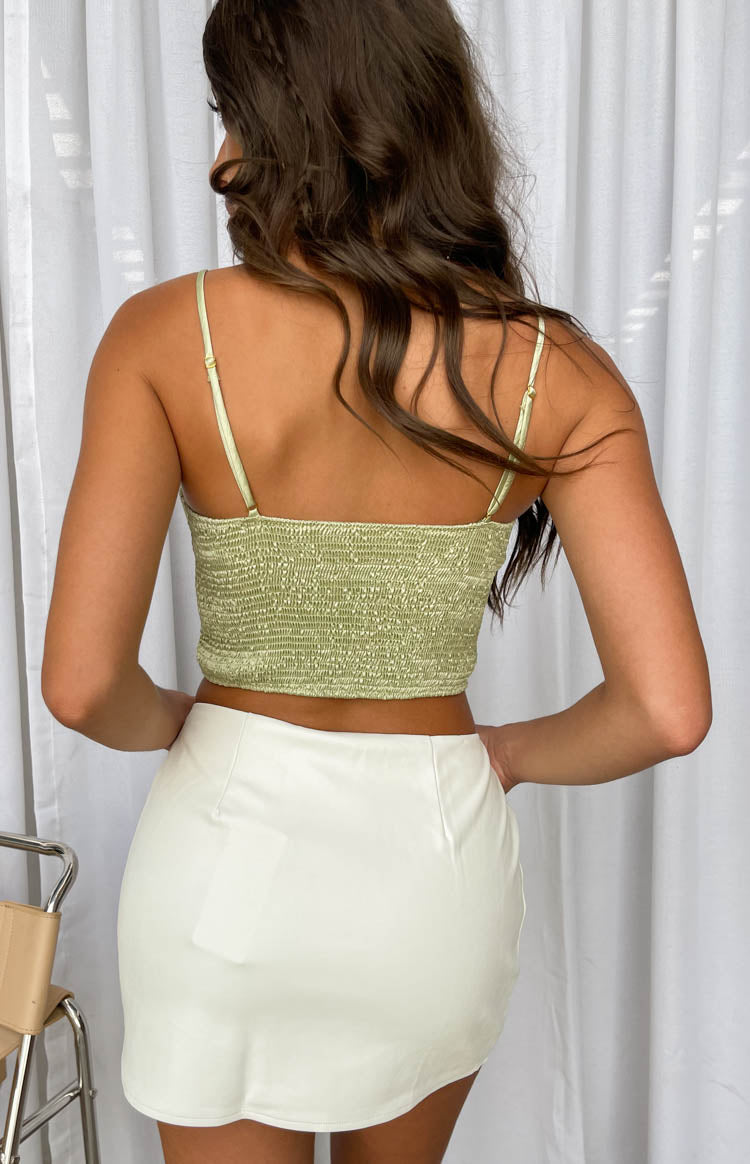 Rear view of a green shirred crop top with an elasticated back and thin adjustable spaghetti straps