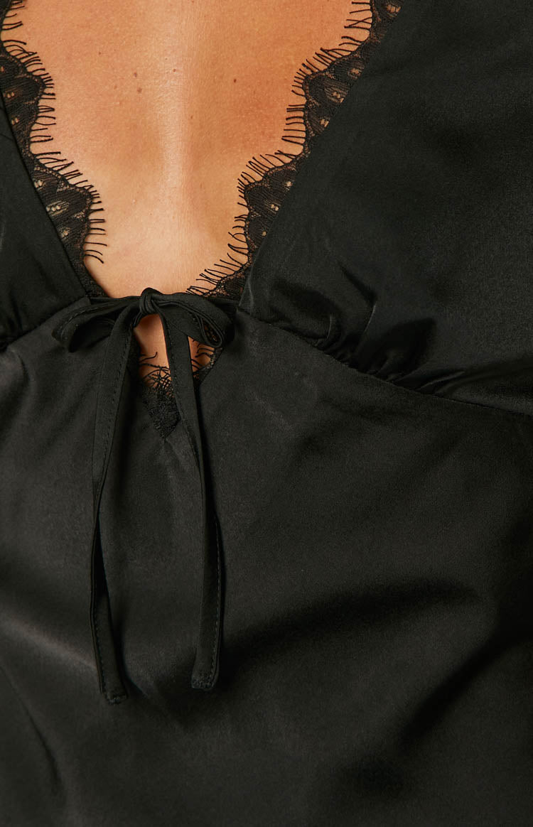 Close-up of the black satin V-neckline with lace trim and a tie-front detail forming a keyhole cutout on the mini dress