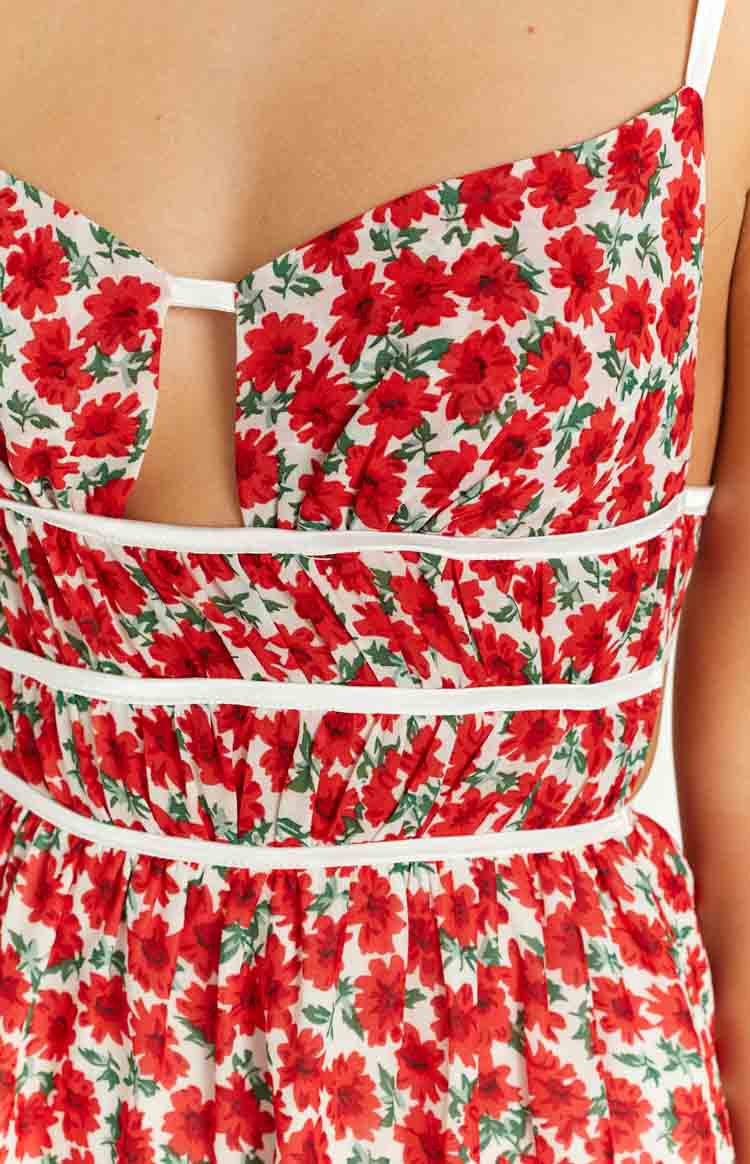 Close-up of the red floral mini dress with a sweetheart neckline cutout and white horizontal trim