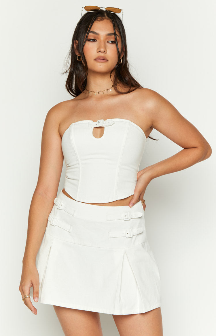 Front detail of the white strapless top featuring a small buckle and keyhole cutout