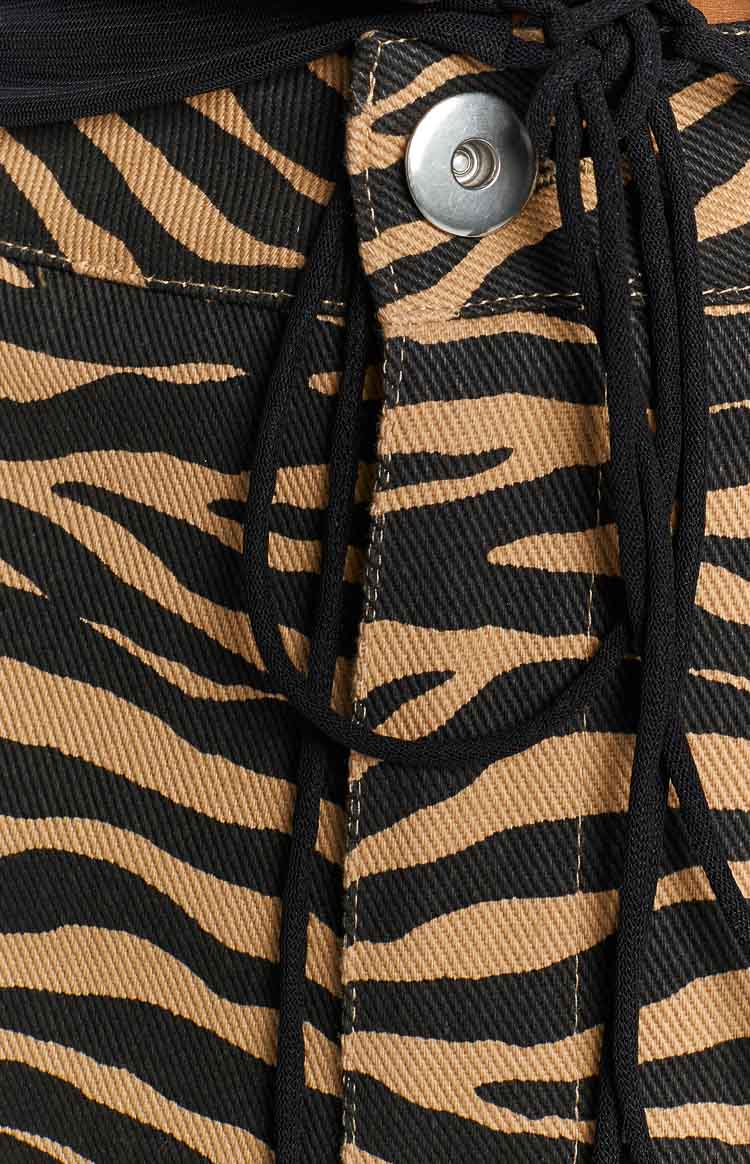 Detail shot of the brown and black zebra print pants showing the black drawstring and silver snap button