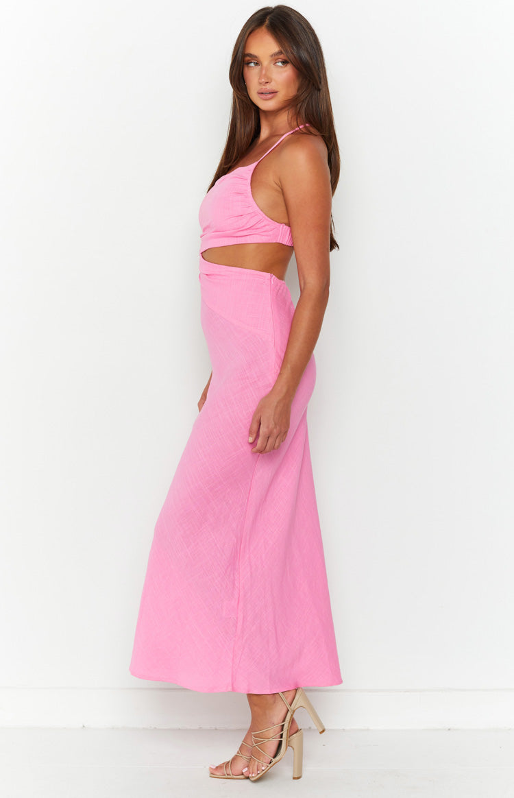 Side view of a pink maxi dress with side waist cutouts, a ruched bust, and thin spaghetti straps