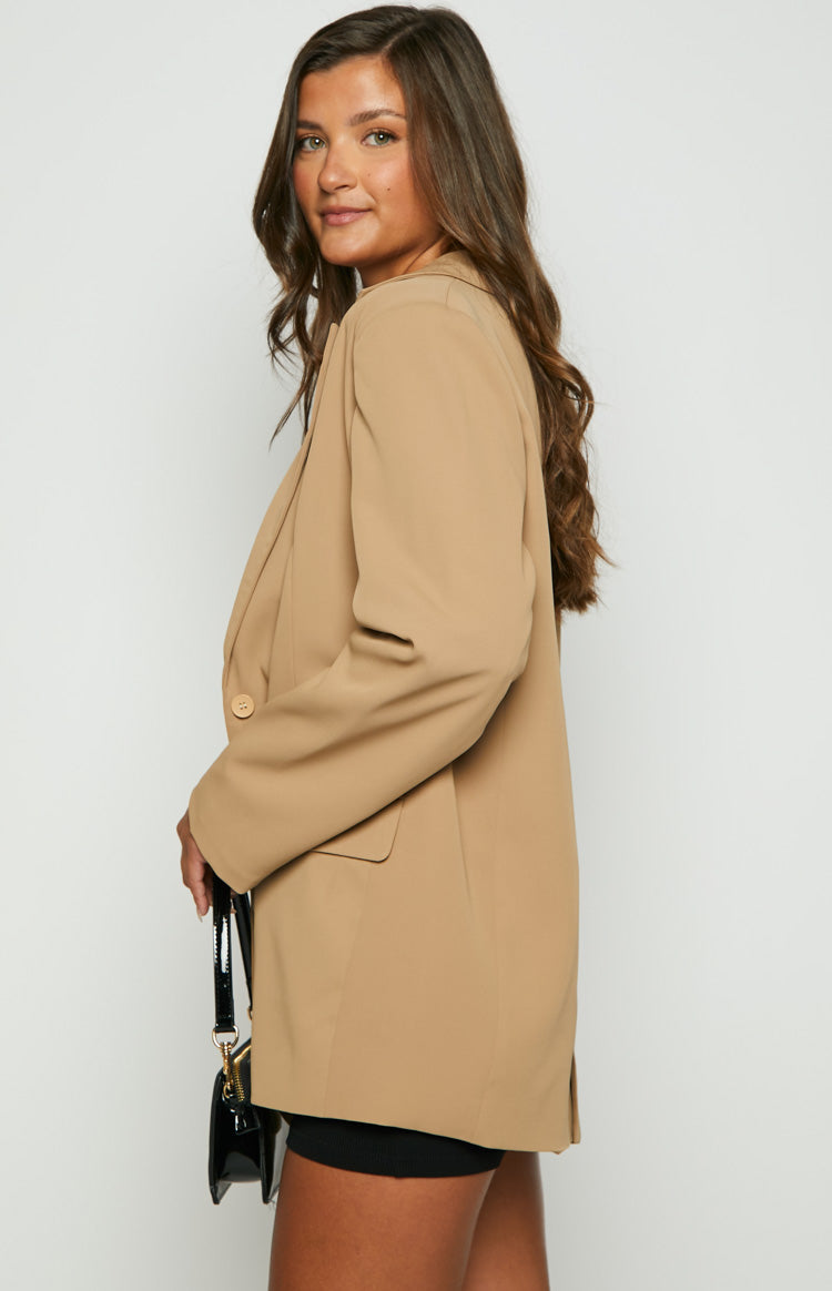 Side view of a tan oversized blazer with a single button closure and notched lapels