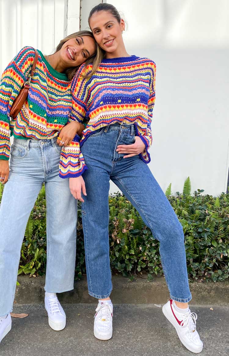 Open crochet knit sweater with vibrant rainbow stripes, blue crew neck and bell sleeves