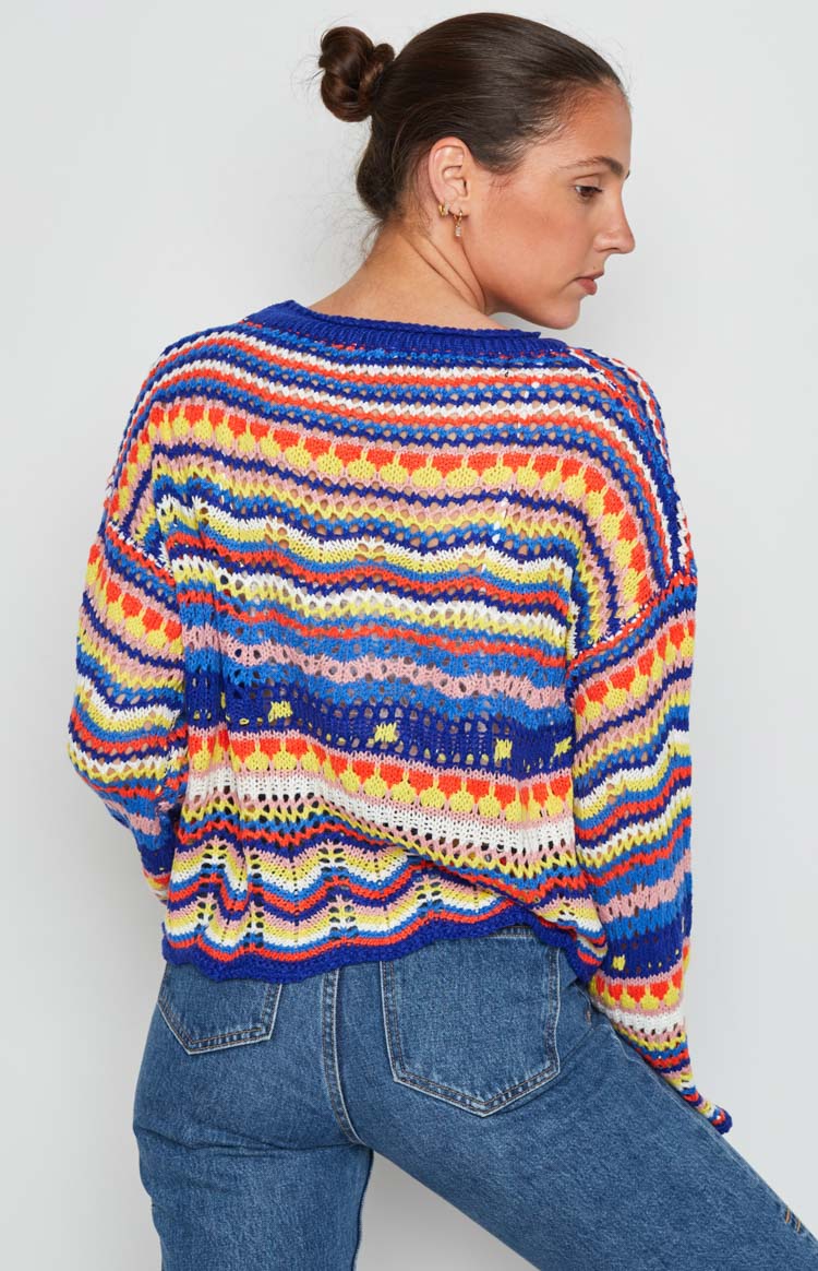 Multi-coloured striped open knit sweater with varied patterns and a scalloped hem