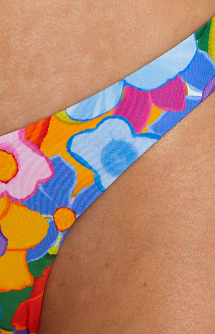 Close-up of the vibrant floral pattern on the bikini bottoms with blue pink yellow and green flowers