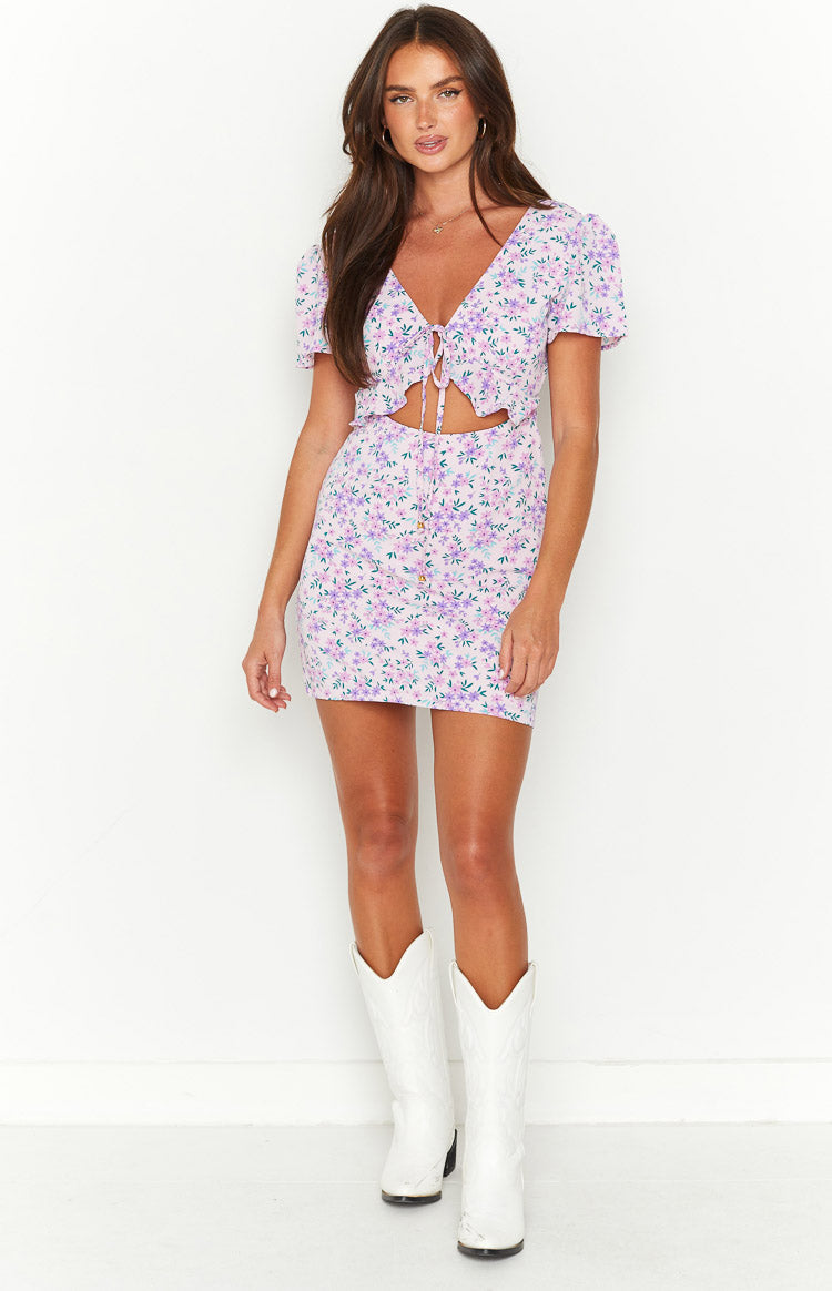 Lilac floral mini dress with V-neck, tie-front, puff sleeves, waist cutouts, and button-front skirt