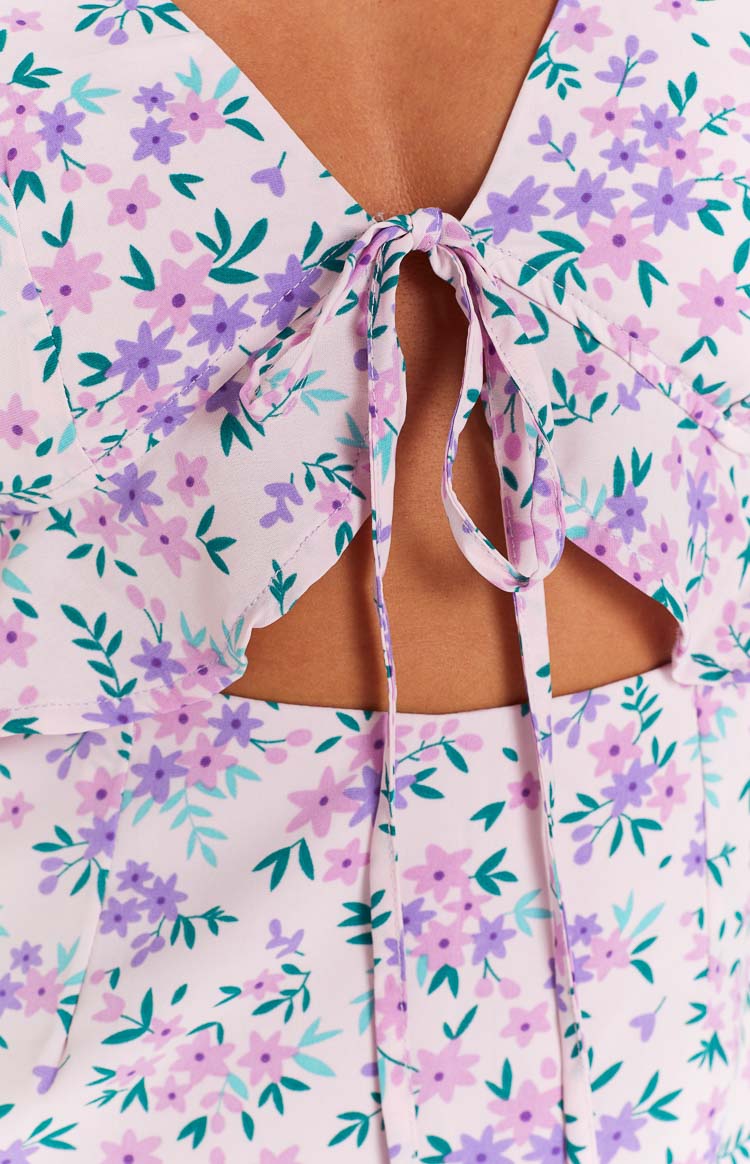 Close-up of the tie-front detail and side cutouts on a lilac floral mini dress