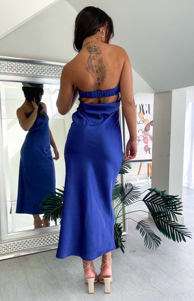 Rear view of a navy satin maxi dress with an open back, ruched elastic band, and side waist cutouts