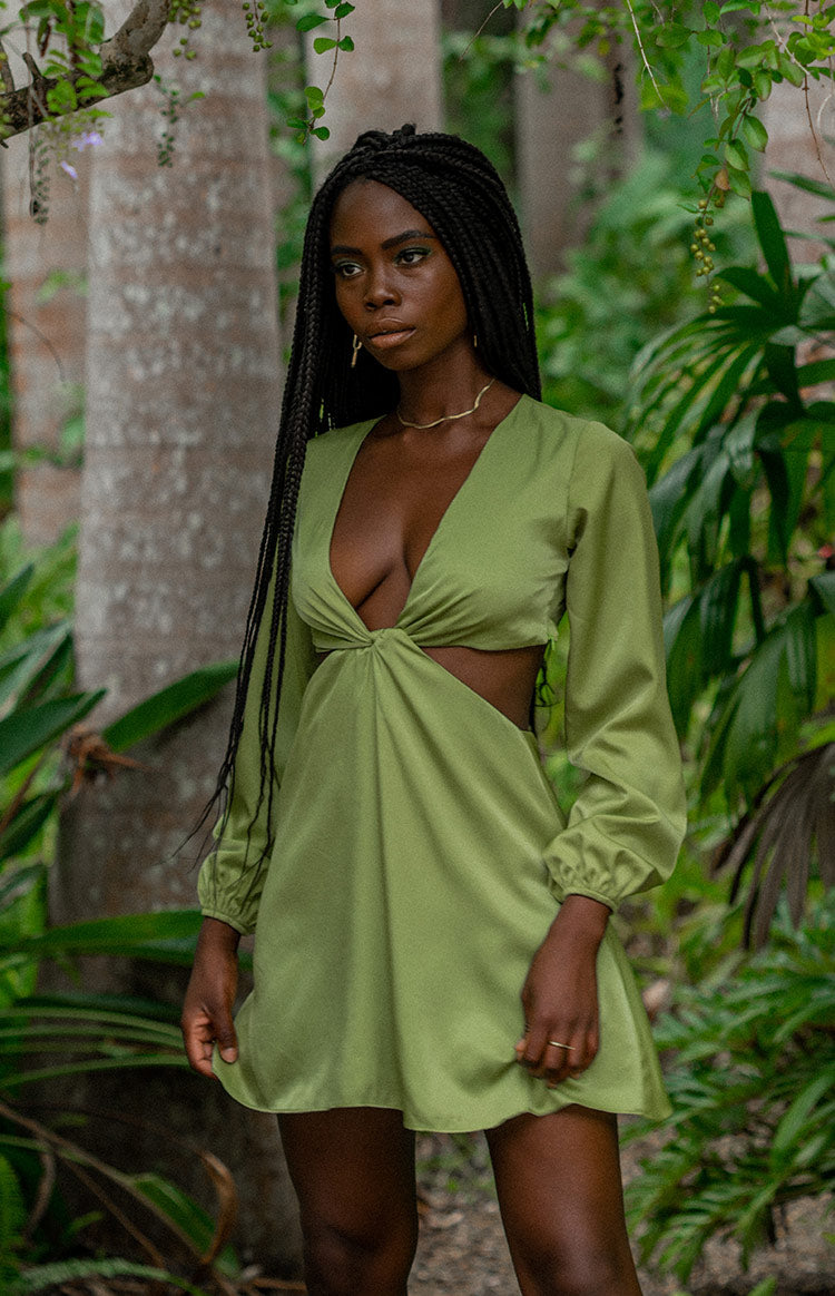 Green mini dress with deep V-neck, twisted bust detail, waist cutouts, and long balloon sleeves