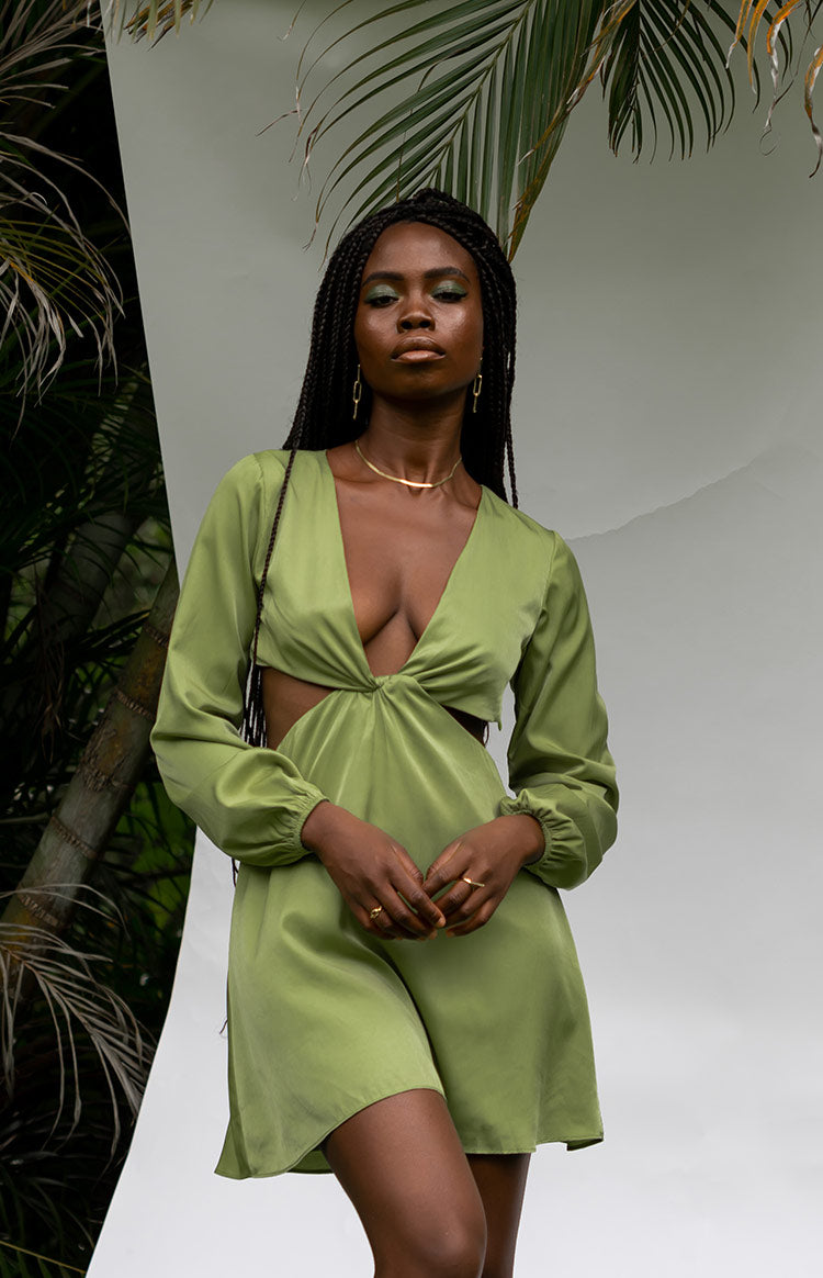 Olive green satin mini dress with a deep V-neckline, long cuffed sleeves, and a twisted front with waist cutouts