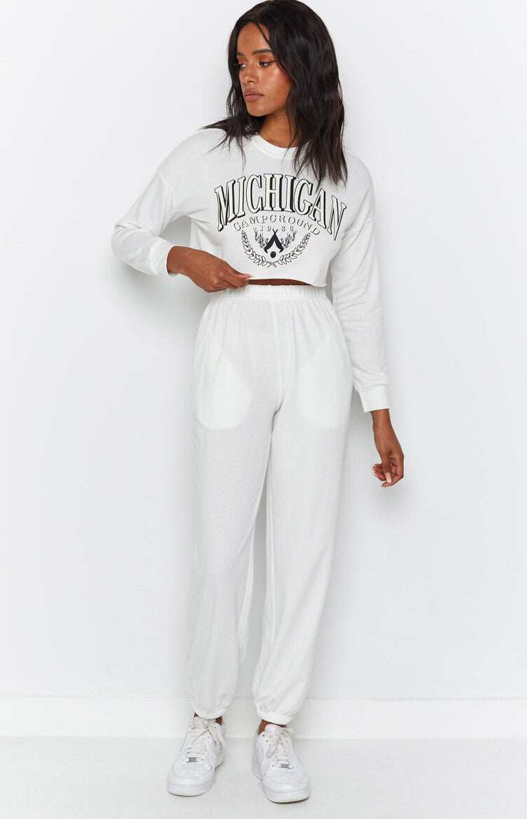 White long sleeve crop top with raw hem and black Michigan graphic, paired with relaxed fit jersey joggers