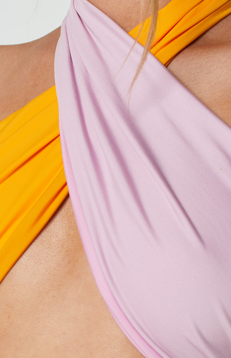 Close-up of the smooth, draped orange and lilac fabric with a twisted detail on the top