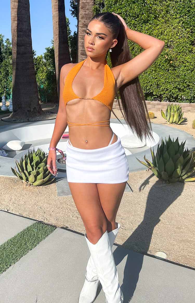 Orange knit halter top with a deep V-neck, underbust gold chain, and wrap-around waist ties