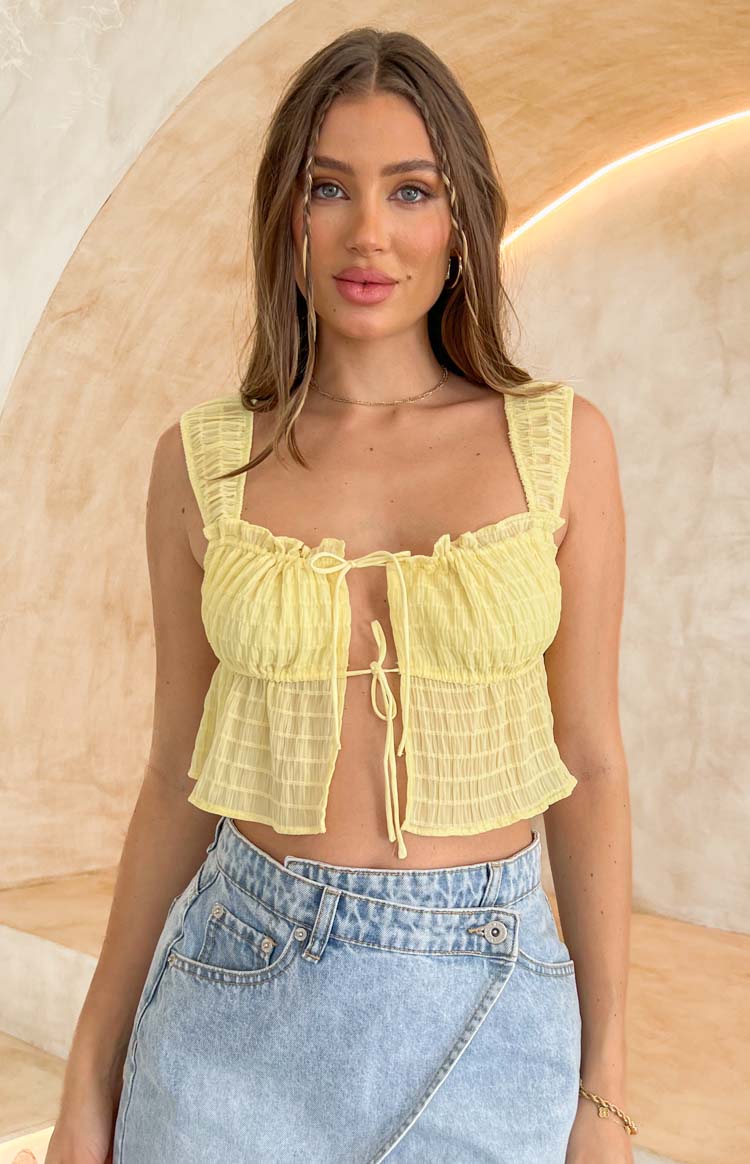 Front view of a yellow sheer textured crop top with a square neckline, wide ruched straps, and a tie-front bust