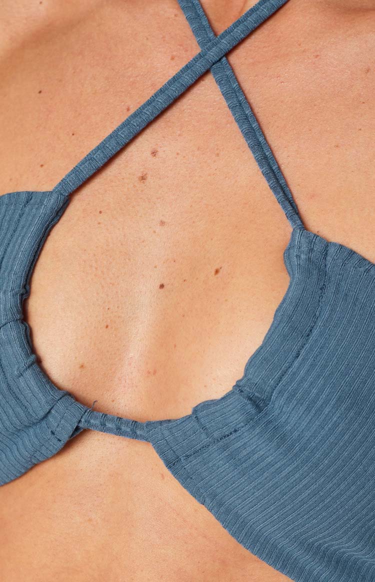 Close-up of the blue ribbed top's criss-cross halter straps and the front keyhole detail