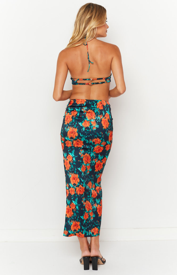 Rear view of a fitted dark blue maxi skirt with a vibrant orange and teal floral pattern
