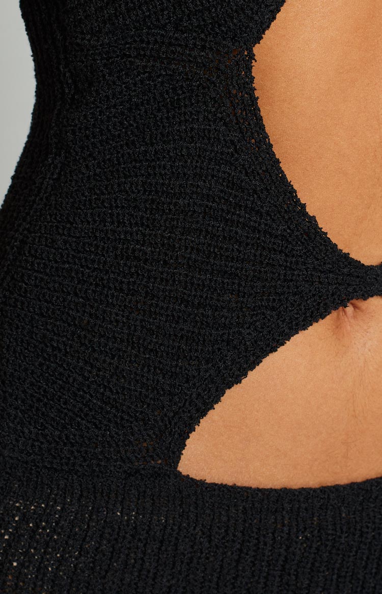 Close-up of the textured black knit fabric and side cut-out detail of the dress
