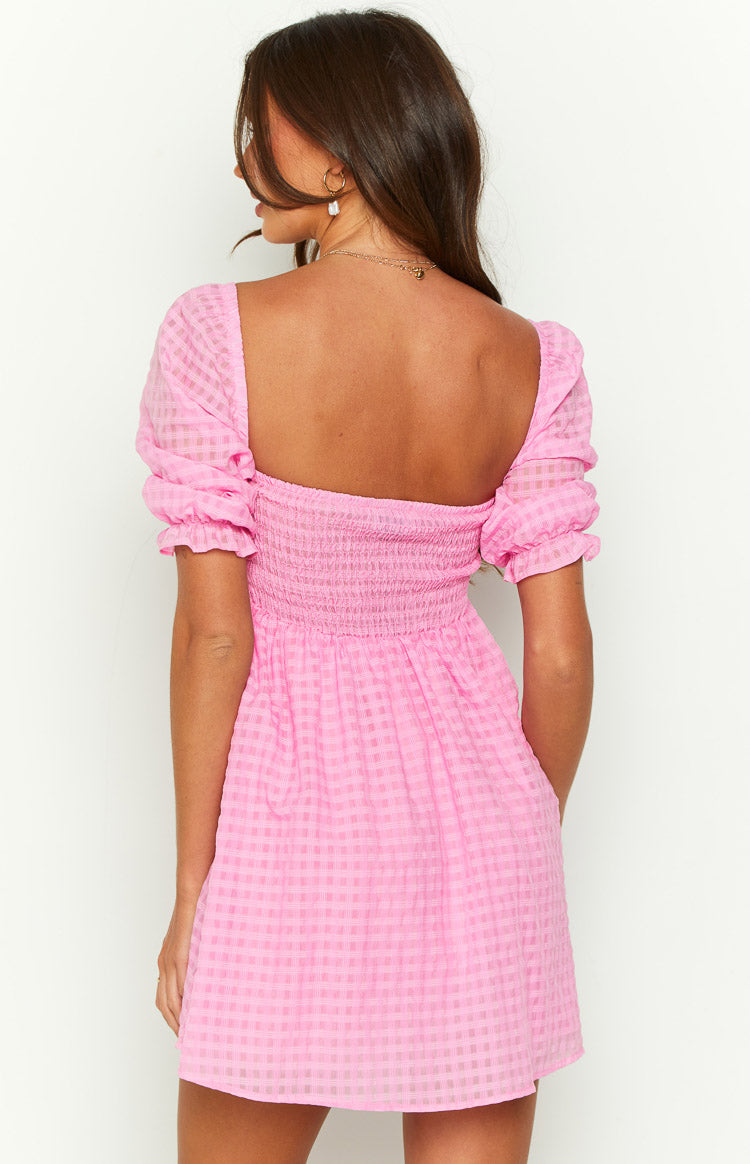 Rear view of a pink gingham babydoll mini dress with a low square back and shirred bodice