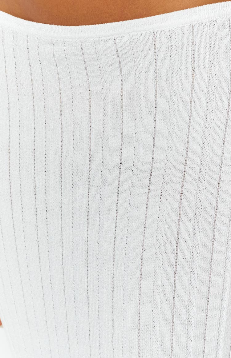 Close-up of the white ribbed knit fabric of the skirt, showing the fine vertical texture and waistband