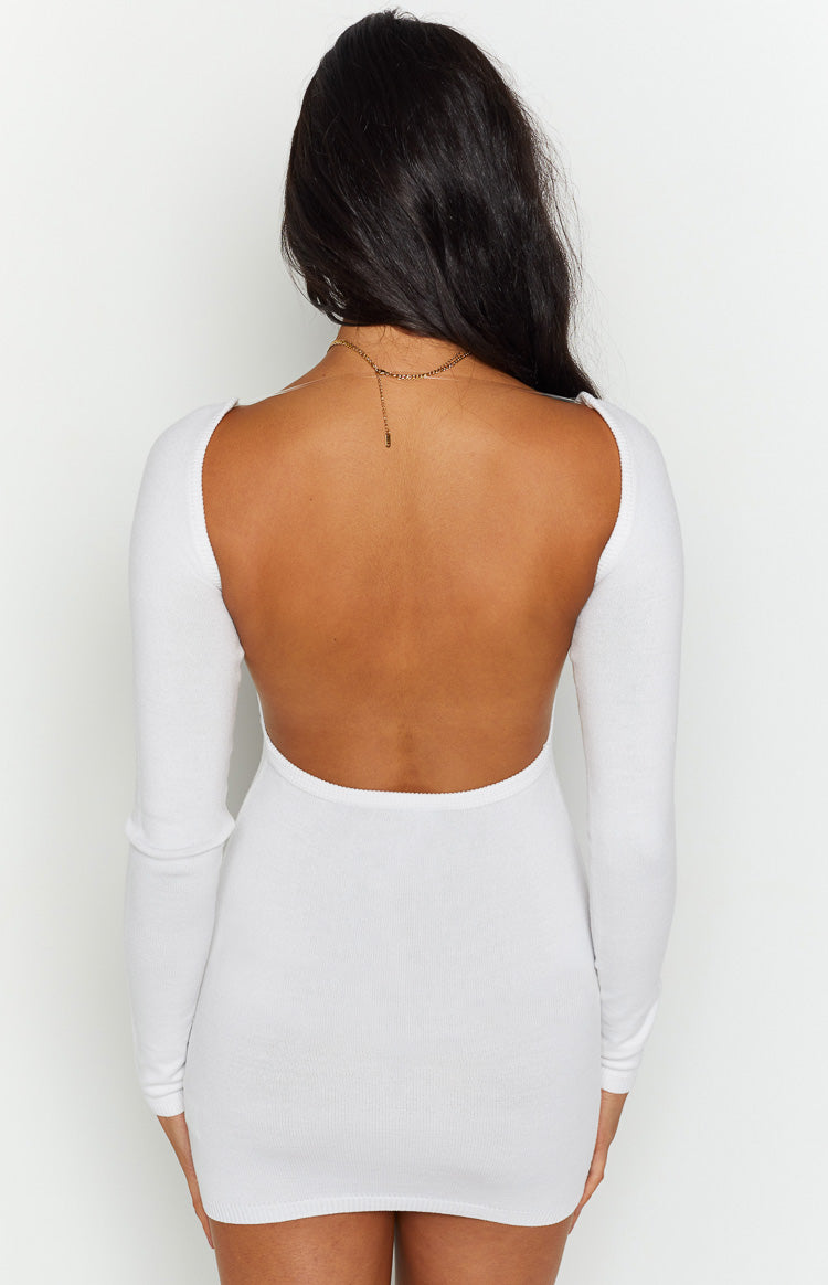 Back view of the white knit dress featuring a wide, low scoop back and fitted long sleeves
