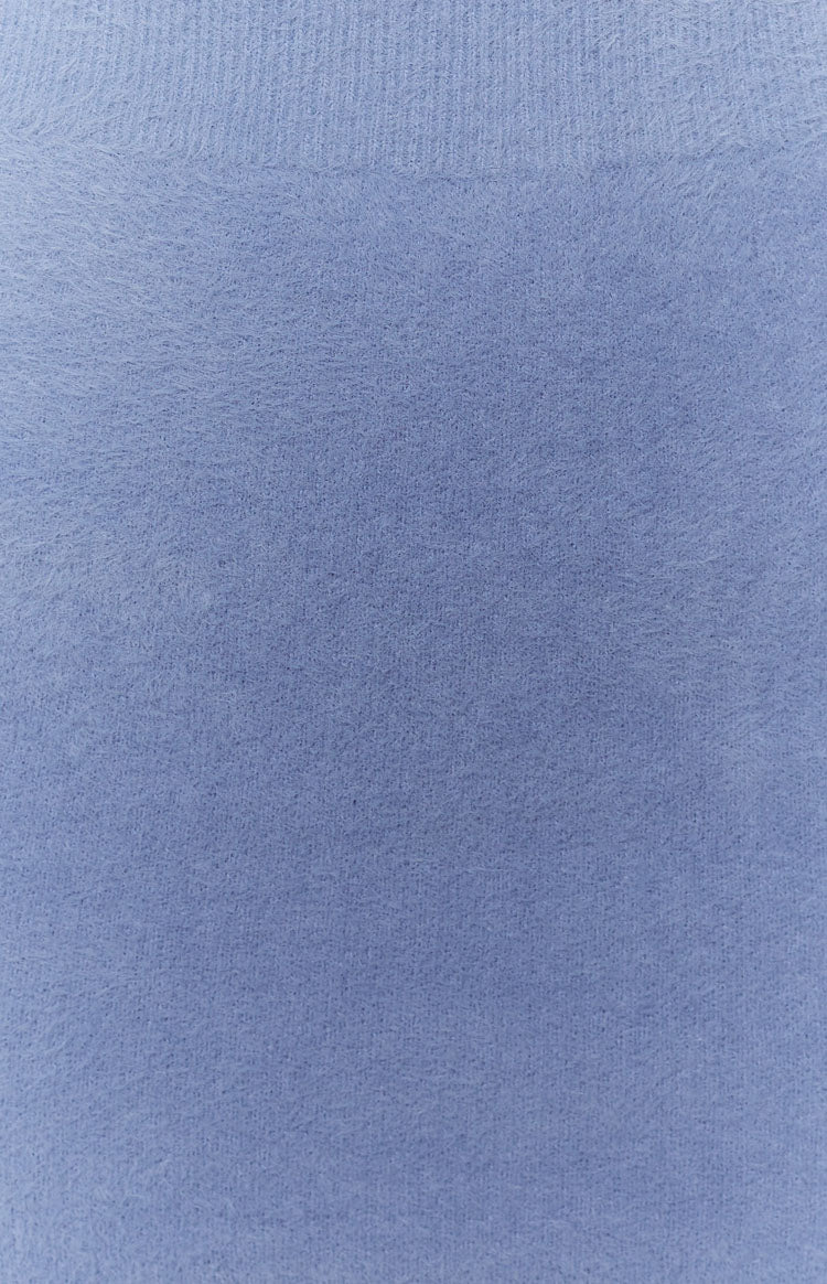 Periwinkle blue fluffy knit fabric close-up with a soft texture and ribbed top edge