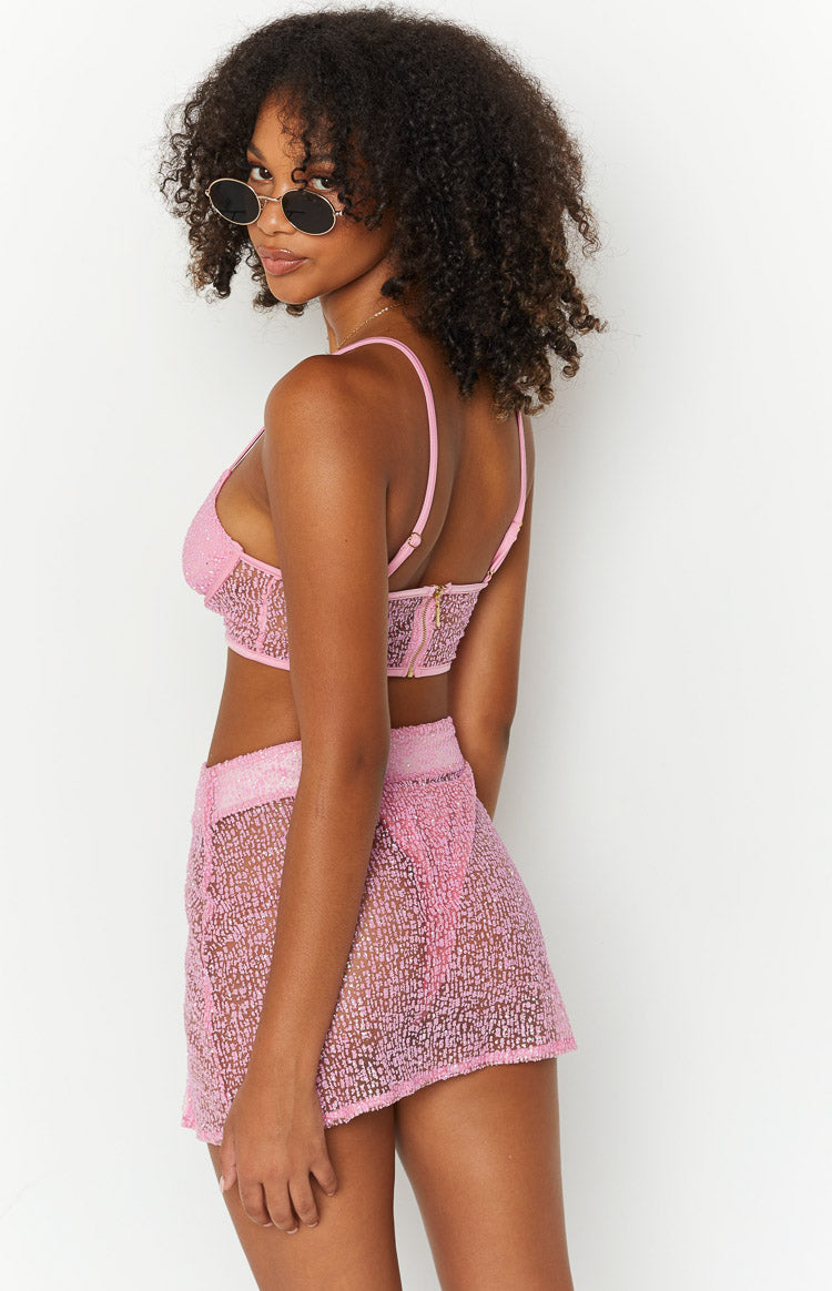 Side view of a pink sparkle bralette with adjustable spaghetti straps and a gold zipper closure at the back