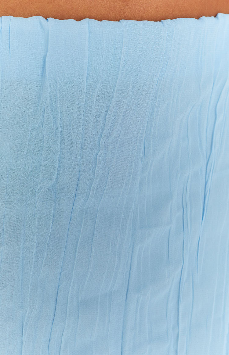 Close-up showing the light blue crinkled texture of the maxi skirt and the ruffled elastic waistband