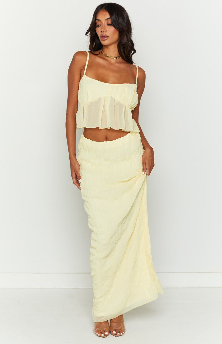 Front view of a light yellow crinkled maxi skirt with a relaxed, flowy silhouette and elasticated waist
