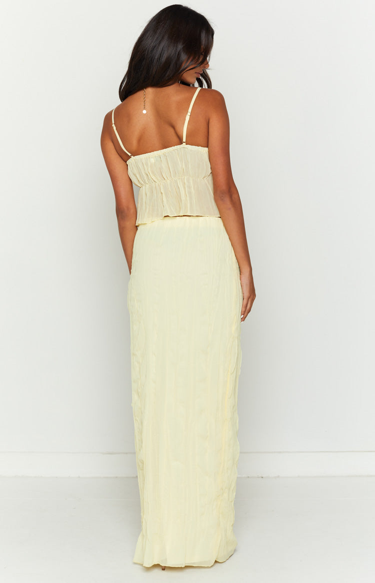Back view of the yellow crinkled maxi skirt, showing the subtle vertical texture and full-length flowy fit
