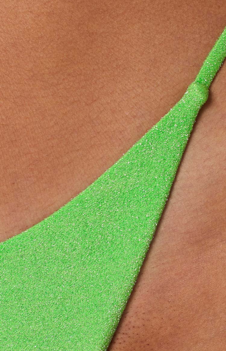 Detail shot of the bright green glitter fabric and a tied strap on the bikini bottom