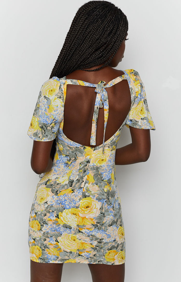 Yellow and blue floral mini dress with an open back and tie closure, short puff sleeves