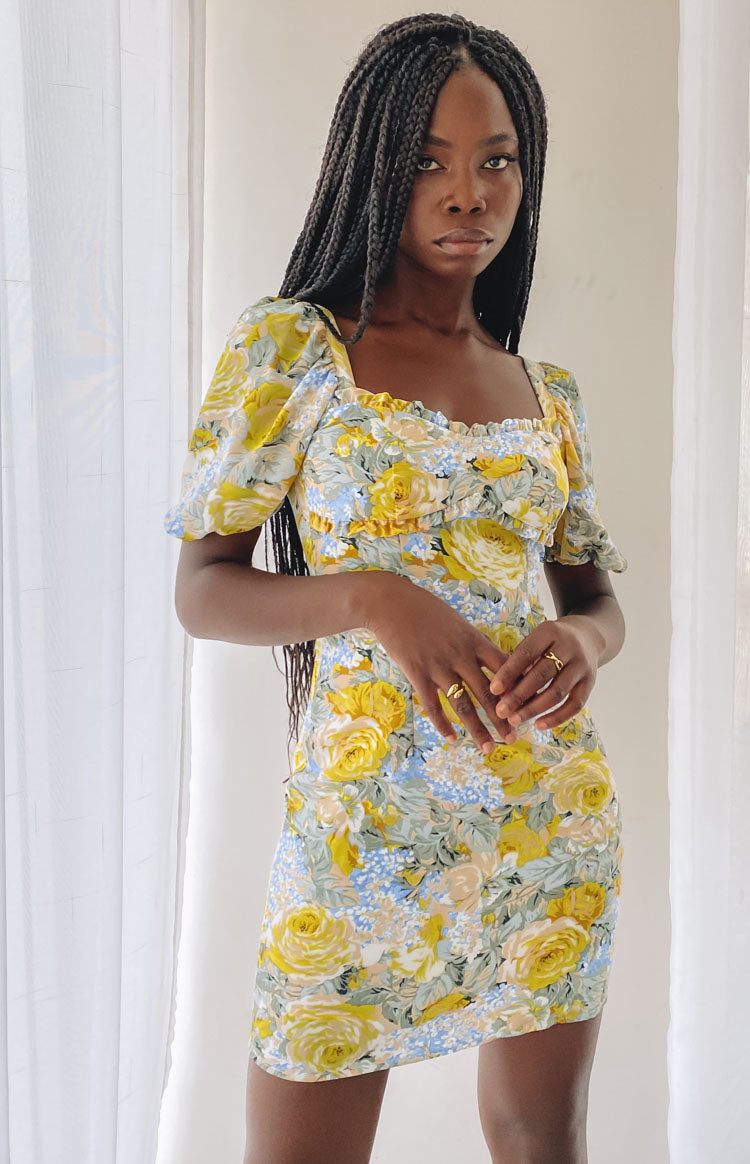 Sweetheart neckline mini dress with ruffled trim, short puff sleeves, and shirred bodice in yellow and blue floral