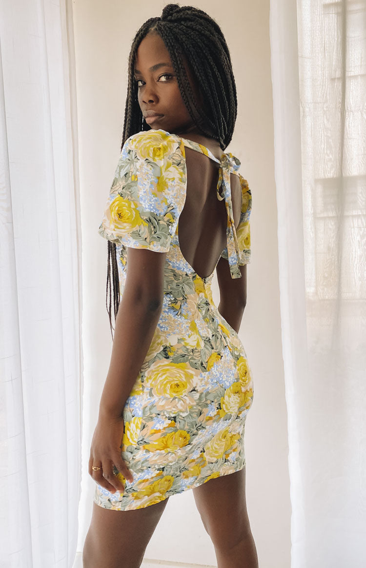 Yellow and blue floral mini dress with a backless design, tie-up neck, and puffed short sleeves