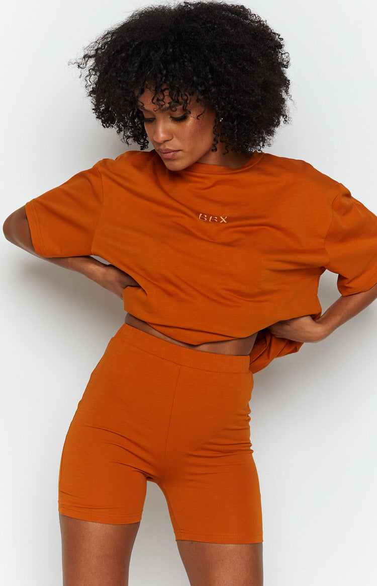 Tan fitted high-waisted mid-thigh shorts in soft jersey, styled with a matching oversized t-shirt