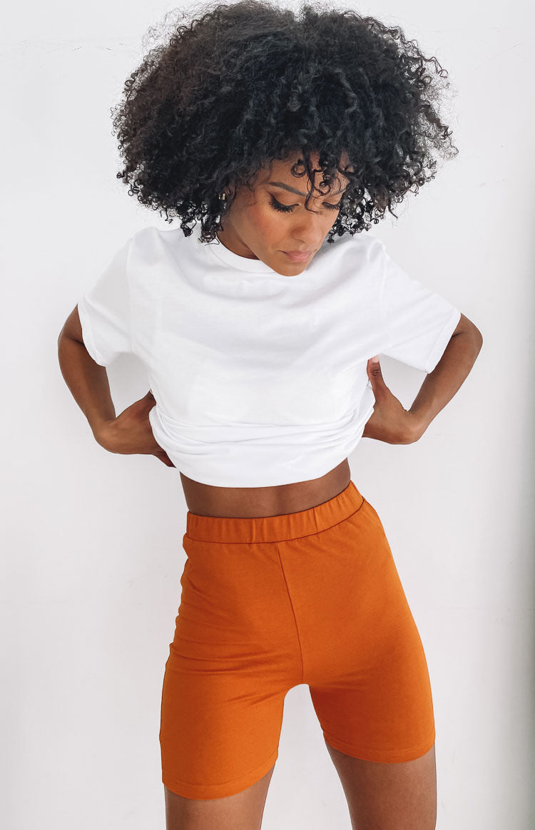 Fitted tan high-waisted stretch shorts with an elastic waistband, biker length