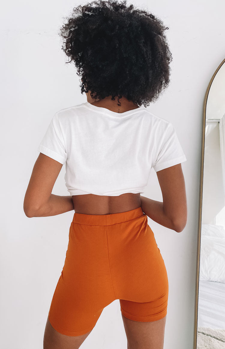 Rust orange high-waisted bodycon shorts in soft jersey fabric, back view
