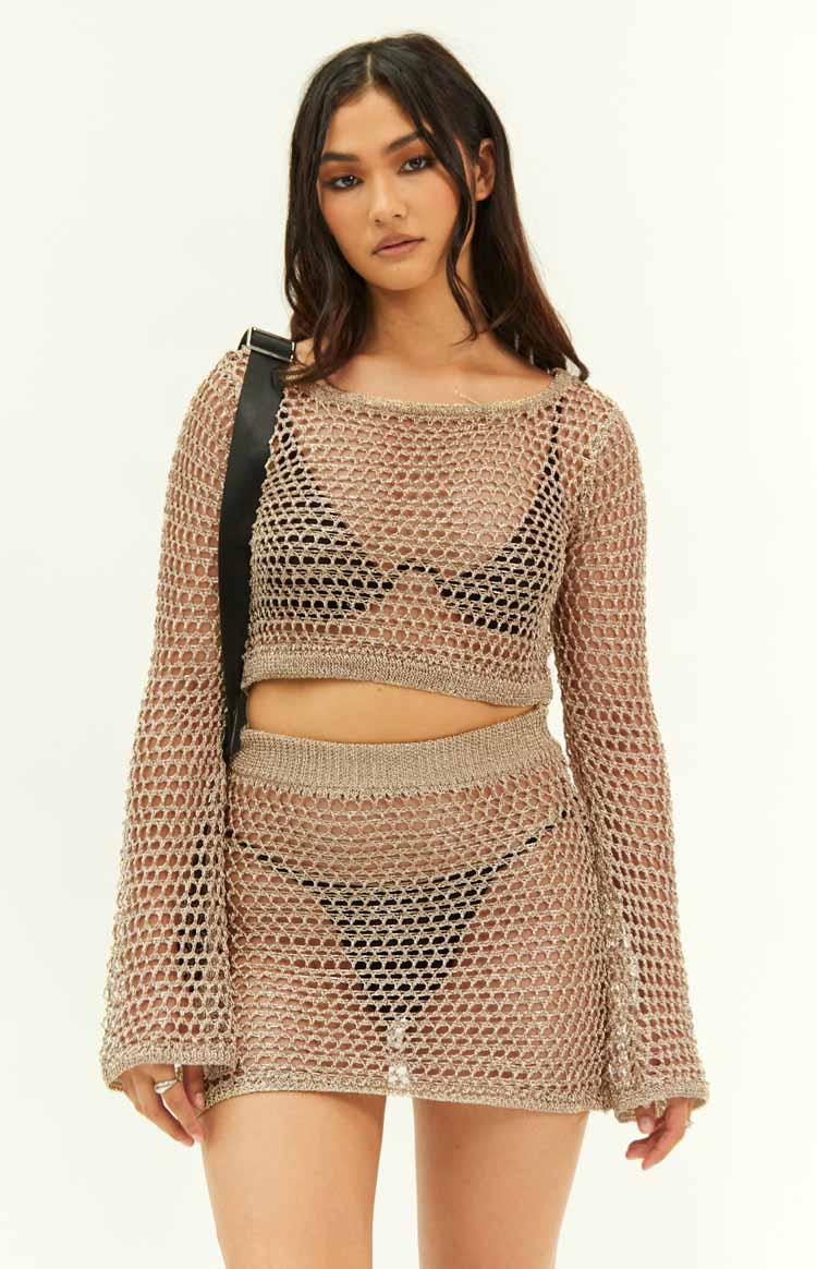 Front view of a gold metallic open knit cropped top with long flared sleeves and a wide neckline