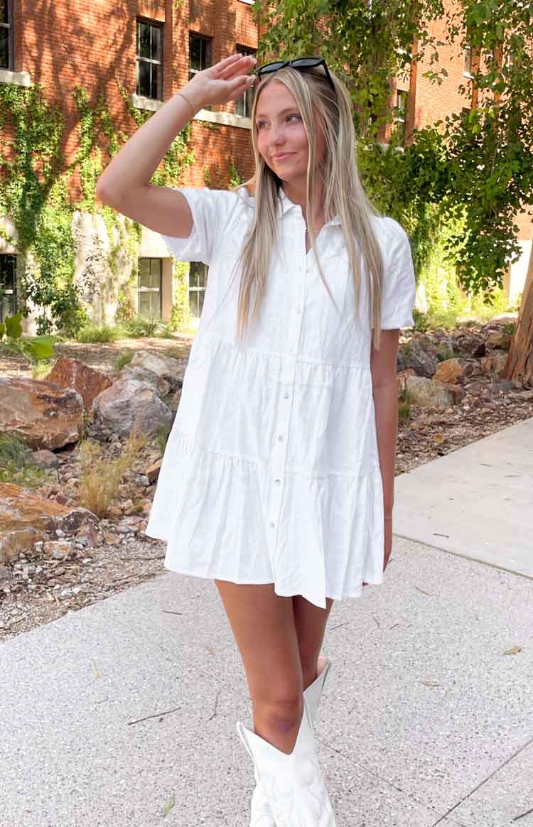 Flowy white linen tiered mini dress with a collared neckline and button-front