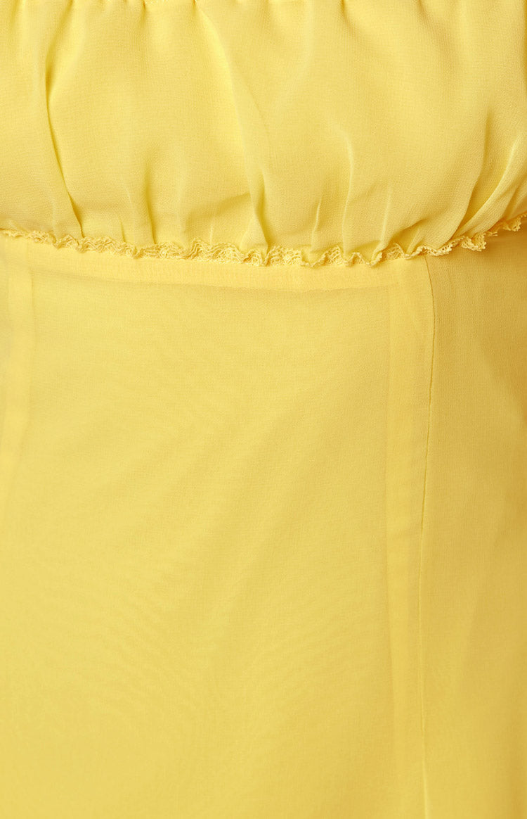Close-up of the ruched bust detail and ruffled trim on the yellow mini dress
